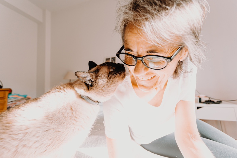cat kissing older woman